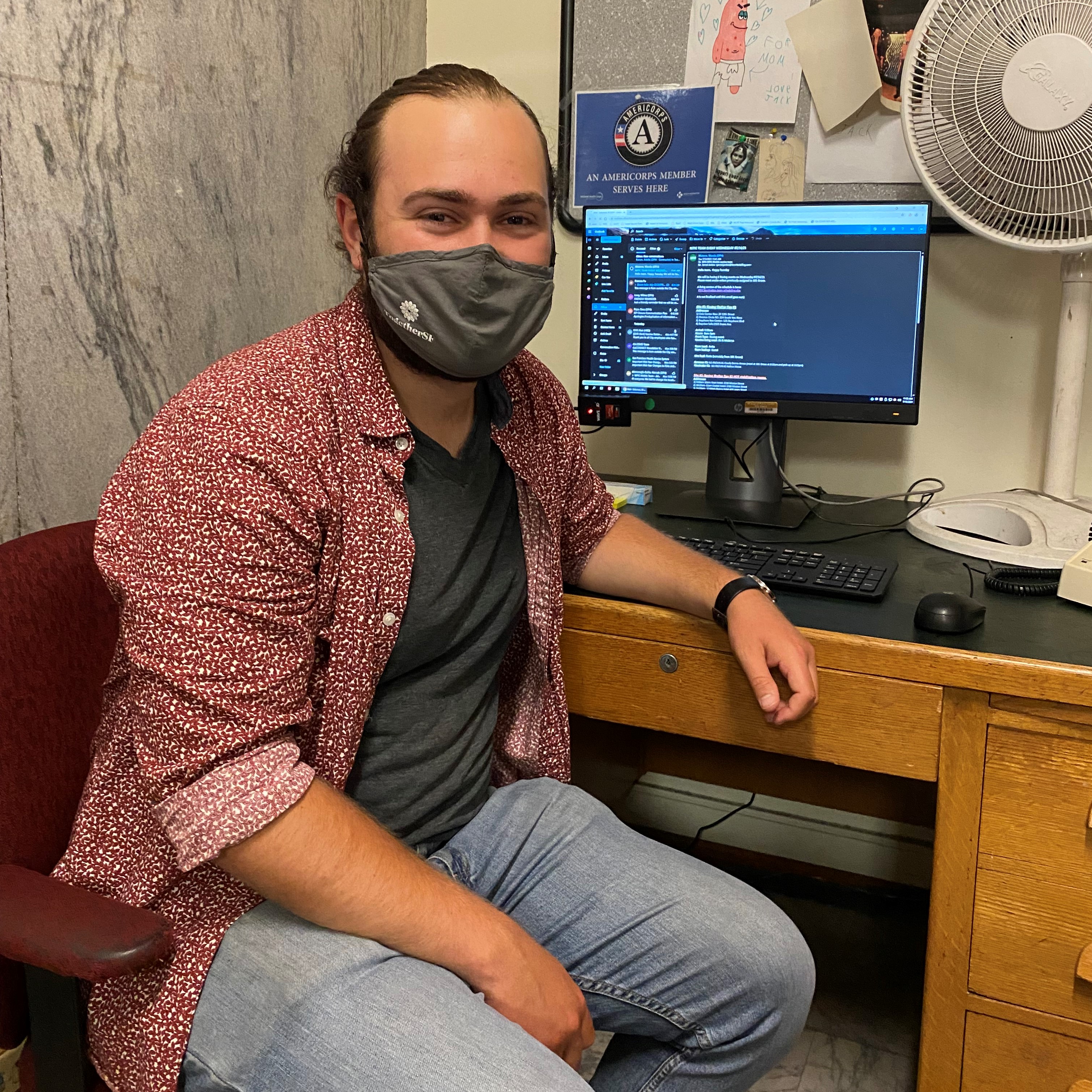 Photo of Eli Solomon at his desk and computer.